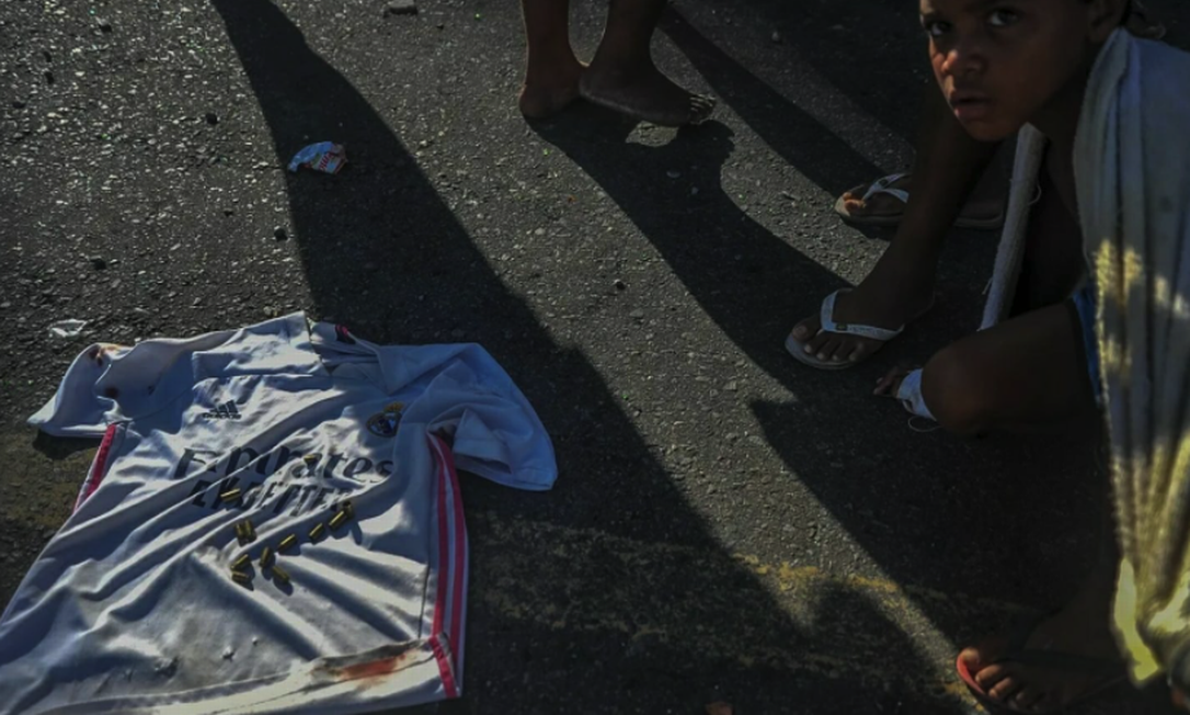 Projéteis colocados por moradores sobre a camisa de uma das vítimas ensanguentada Foto: Felipe Iruatã